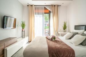 Un dormitorio con una cama y un televisor y una ventana. en ArtApart Stare Miasto Wrocław, en Wroclaw