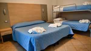 twee bedden in een hotelkamer met handdoeken erop bij Hotel Etoile in Rimini