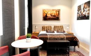 a hotel room with a bed and a table at City HotelApartment in Karlshamn