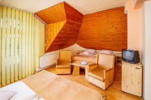 um quarto com uma cama e uma televisão em Hotel Castel em Sfântu Gheorghe