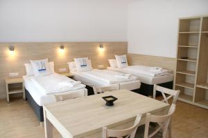 a room with four beds and a table and chairs at Miratel in Mitterteich