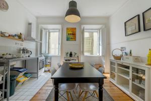 een keuken met een tafel en stoelen in een kamer bij The Color Hostel in Lissabon +73 foto's