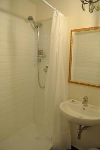 baño blanco con ducha y lavamanos en Palazzo Zecchino B&B, en Génova