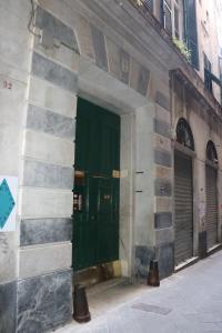 una puerta verde al lado de un edificio en Palazzo Zecchino B&B, en Génova