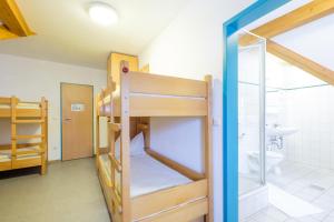 Zimmer mit einem Etagenbett, 2 Etagenbetten und einem Badezimmer. in der Unterkunft Jugendherberge Burg Trausnitz in Trausnitz