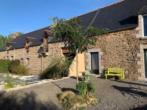 a brick building with a yellow bench in front of it at Mont Voyageur in Sains