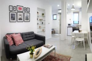 een woonkamer met een bank en een tafel bij Modern Home In The Heart of Nachlaot in Jeruzalem