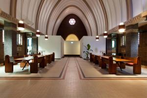 een kerk met houten banken en een gewelfd plafond bij B&B de Kerk in Doorwerth