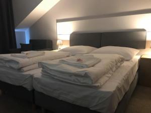 1 dormitorio con 2 camas con sábanas y almohadas blancas en Różany Zakątek, en Pakosław