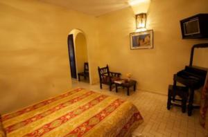 a bedroom with a bed and a piano at Hotel Amalay in Marrakesh