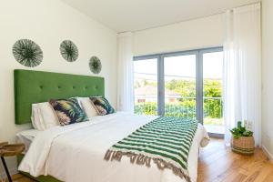 a bedroom with a large bed and a large window at Mama Coco Cascais Apartments in Cascais