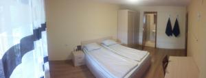 ein Schlafzimmer mit einem weißen Bett in einem Zimmer in der Unterkunft Трънската къща in Trŭn