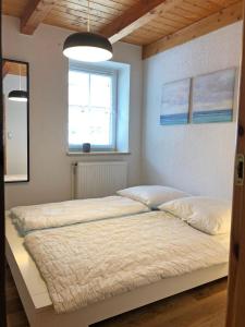 a large bed in a bedroom with a window at Schöne Ferienwohnung 120qm 4+2 Pers. in Fehmarn