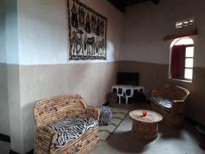 a room with two wicker chairs and a table at NENA HOUSE in Rusatira
