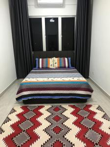 um quarto com uma cama com um tapete colorido em Wan Homestay Putra Impian em Kajang