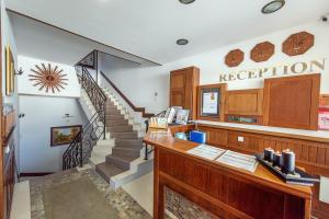 - un bureau avec une réception et des escaliers dans l'établissement MPM Family Hotel Merryan, à Pamporovo