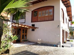 a house with a front door and a palm tree at Pousada Recanto das Marias in Santo Antônio do Pinhal