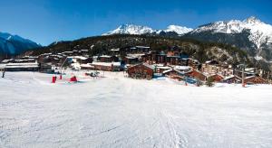 ラ・ノルマにあるVacancéole - Résidence Les Chalets et Balcons De La Vanoiseの雪をかぶった山々の雪の中のスキー場