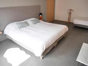 uma grande cama branca com duas almofadas em Le Chat Qui Dort - Suites em Lille