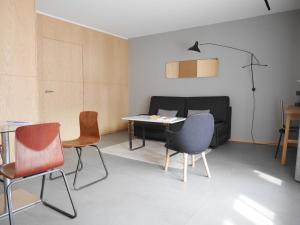a room with chairs and a table and a couch at Le Chat Qui Dort - Suites in Lille