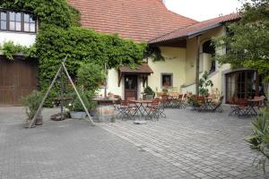 eine Terrasse mit Tischen und Stühlen in einem Gebäude in der Unterkunft Weingut Schilling in Seinsheim