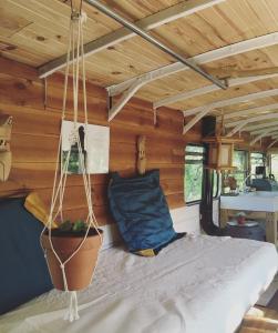 Ce lit se trouve dans un dortoir doté de murs en bois. dans l'établissement Cosmic English Bus 2 floor, à Mimizan
