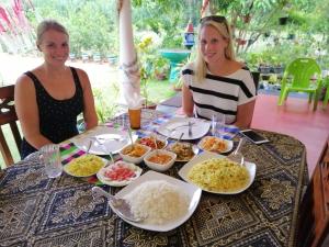 two women sitting at a table with plates of food at Sigiriya Thilini Homestay in Sigiriya +50 photos