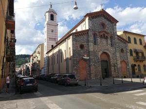 a building with a clock tower and cars parked on the street at La Soffitta di Maria in La Spezia