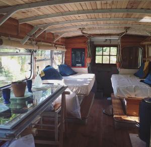 ein Zimmer mit 2 Betten und einem Tisch in einem Bus in der Unterkunft Cosmic English Bus 2 floor in Mimizan