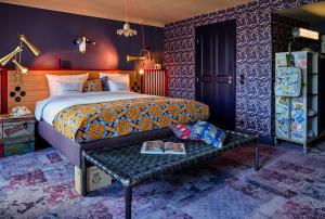 a bedroom with a bed and a bench with a book at 25hours Hotel Terminus Nord in Paris