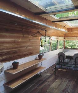 ein Zimmer mit einer Bank und einem Tisch in einer Hütte in der Unterkunft Cosmic English Bus 2 floor in Mimizan