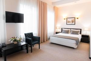 um quarto de hotel com uma cama e uma cadeira em Maksim Gorkiy Hotel em Kazan