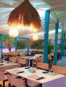 Un restaurante con mesas y sillas blancas y luces. en Gwadakreyol, en Saint-François