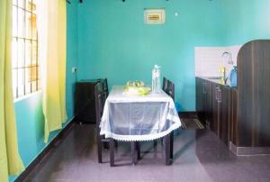 a table in a room with a blue wall at Coorg Annu Stays And Cottages in Madikeri