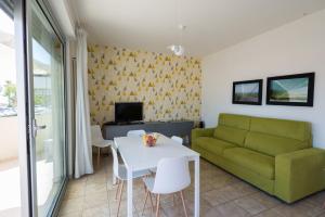 sala de estar con sofá verde y mesa en Residenza Alpaluba, en Vasto
