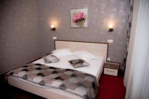 a bedroom with a bed with two pillows on it at Hotel Stefani in Sibiu