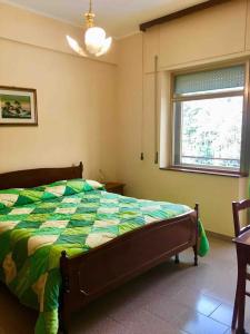 a bedroom with a bed with a green comforter and a window at La Terrazza di Filomena - Picinisco, Parco Lazio & Abruzzo in Picinisco