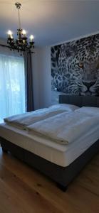 a bed in a bedroom with a painting on the wall at Enjoyit Velden West in Selpritsch