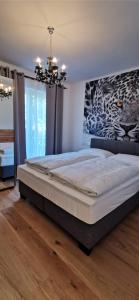 a large bed in a bedroom with a chandelier at Enjoyit Velden West in Selpritsch