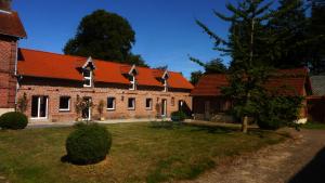 un grand bâtiment en briques avec un toit rouge dans l'établissement Florimont - Vaste gîte à la ferme, à Villers-Châtel