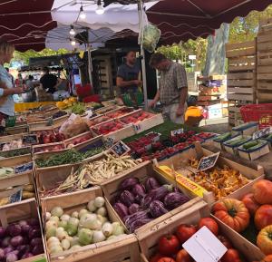 un mercato agricolo con scatole di frutta e verdura di Apartment Pont Romain a Vaison-la-Romaine