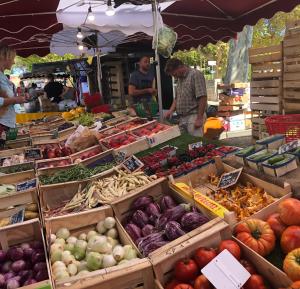 a farmers market with boxes of fruits and vegetables at Apartment Pont Romain in Vaison-la-Romaine