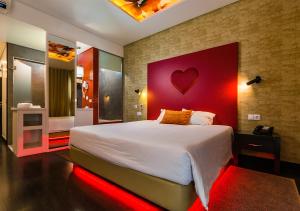 - une chambre avec un grand lit et une tête de lit rouge dans l'établissement Lisotel - Hotel & Spa, à Leiria