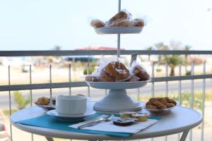 a table with a tray of pastries on a balcony at NARANJA in Marina di Schiavonea