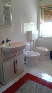 Un baño blanco con lavabo e inodoro. en villa gio con piscina, en Siracusa