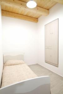 une chambre blanche avec un lit et un miroir dans l'établissement La casa di nonno Enrico vicino alle Cinque Terre, à Riccò del Golfo di Spezia