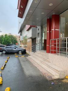 un coche aparcado en un aparcamiento fuera de un edificio en منازل بجيلة للاجنحة الفندقية Manazel Begela Hotel Apartments, en Taif