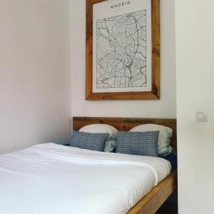 Columbus Apartments Co-Living في لاس بالماس دي غران كاناريا: سرير في غرفة مع خريطة على الحائط
