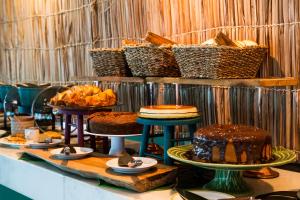 einen Tisch mit verschiedenen Arten von Kuchen und Gebäck in der Unterkunft Hotel Ilhabela in Ilhabela