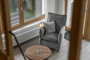 a living room with a chair and a table at Ferienwohnungen Alpentraum - Landhaus Gutermann in Oberstdorf